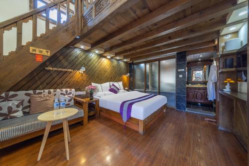 丽江Yingxue Inn Duplex Suite Loft的房间里有一张床和一张沙发的卧室