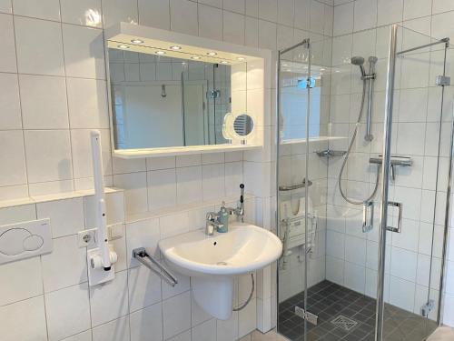 a white bathroom with a sink and a shower at Haus am Anker in Hüde