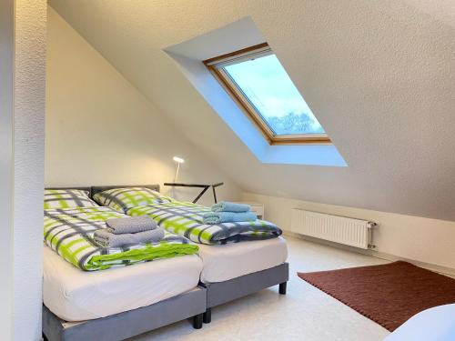 a attic bedroom with two beds with a skylight at Haus am Anker in Hüde