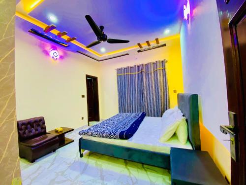 a bedroom with a bed and a ceiling fan at Moonlight Guest House in Rawalpindi