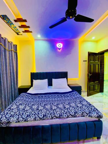 a bedroom with a bed with a ceiling fan at Moonlight Guest House in Rawalpindi