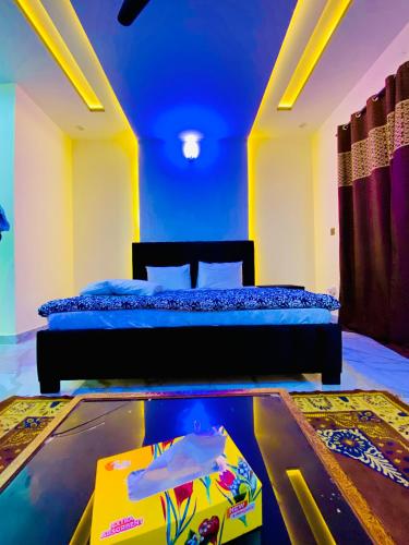 a bedroom with a bed and a table with a box at Moonlight Guest House in Rawalpindi