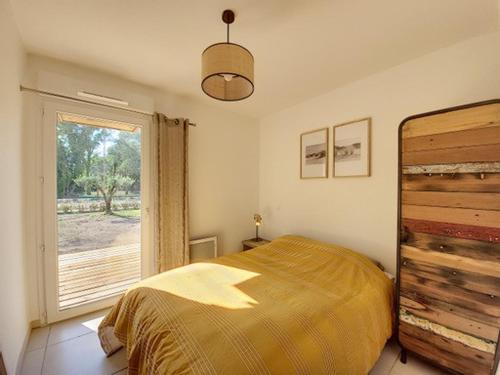 une chambre avec un lit et une grande fenêtre dans l'établissement Villa T4 jardin clim solarium pisc menage draps, à Vias