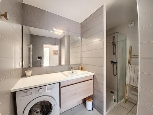 une salle de bain avec une machine à laver et un lavabo dans l'établissement Villa T4 jardin clim solarium pisc menage draps, à Vias