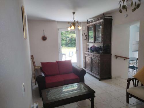 un salon avec un canapé rouge et une table dans l'établissement Ref 018 2 Maison pour 2 personnes avec grand jardin partagé, à Arzon