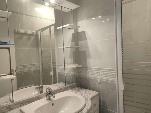une salle de bain blanche avec un lavabo et un miroir dans l'établissement Ref 018 2 Maison pour 2 personnes avec grand jardin partagé, à Arzon