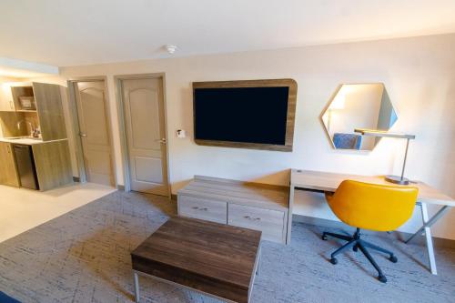a living room with a desk and a yellow chair at Holiday Inn Express - Neptune by IHG in Neptune City