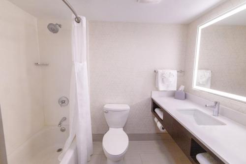 a white bathroom with a toilet and a sink at Holiday Inn Express - Neptune by IHG in Neptune City