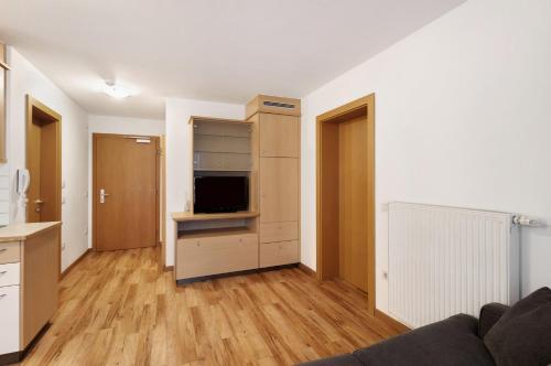 a living room with a couch and a kitchen with a tv at Residence Linderhof in Naz-Sciaves