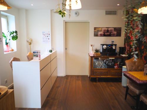 a room with a kitchen with a counter and a table at La Marilyn by Leslodgespa - Confort haut de gamme, salle de bain privée, jardin et cuisine commune, à 5 minutes de l'aéroport in Blotzheim