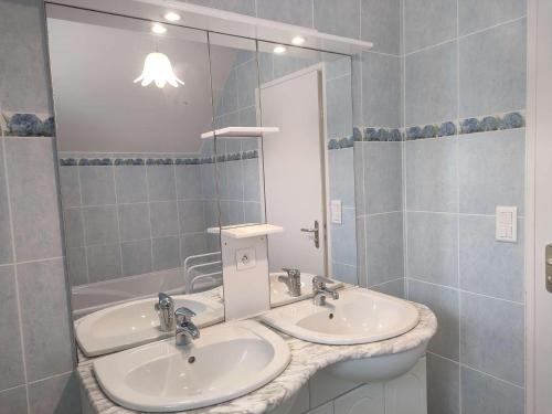 une salle de bain avec deux lavabos et un grand miroir dans l'établissement 018 6 KERNERS maison pour six personnes à louer avec jardin partagé, à Arzon