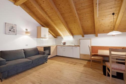 a living room with a couch and a table and a kitchen at Residence Linderhof in Naz-Sciaves