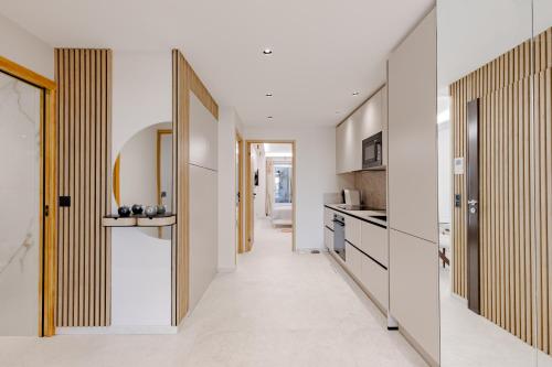 un couloir menant à une cuisine aux murs blancs dans l'établissement Cannes apartment sea view - 18H, à Cannes