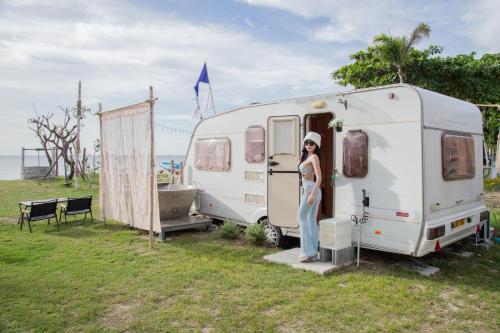a woman standing in the doorway of a white trailer at White House Beach Camping Caravans in Ban Thai Don (2)