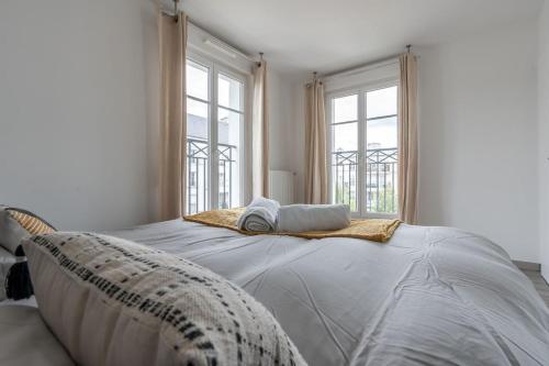une chambre avec un grand lit avec deux fenêtres dans l'établissement Disney à Paris - Scandinaves 01, à Serris