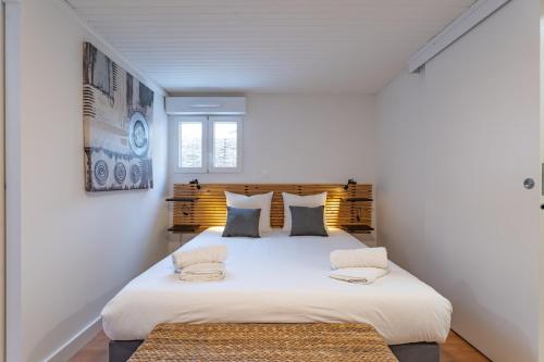 - une chambre blanche avec un grand lit et 2 oreillers dans l'établissement Arcachon centre 4 couchages accès plage, à Arcachon