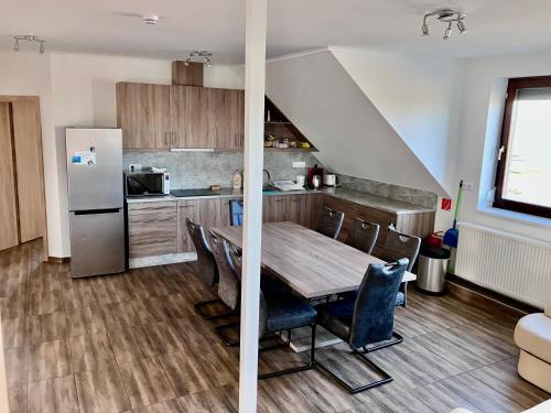 a kitchen with a wooden table and a refrigerator at Mátyás Vendégház 3 Rooms Apartment in Kópháza