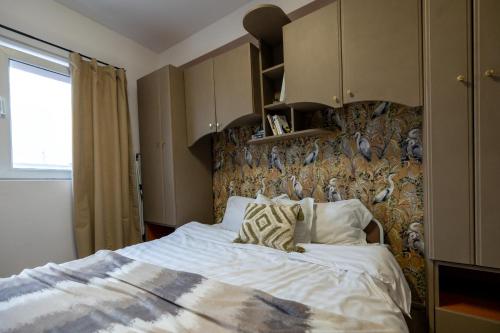 una camera da letto con un letto con un muro con gli uccelli di Cozy Studio Retreat - Quiet, Premium Stay a Timişoara