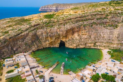 an aerial view of a beach with a cave in the cliff at Ta'Battista B&B with pool - Gozo in Xewkija