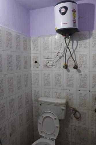 a small bathroom with a toilet and a water tank at Mother's Homestay in Lucknow