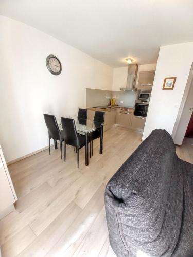 un salon avec un canapé, une table et des chaises dans l'établissement Appartement charmant à Chambéry de 35 m² + balcon privatif, à Chambéry