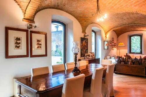 a dining room with a wooden table and chairs at Origine Country Farm in Tabiano