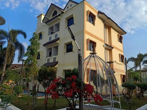 a building with a bird cage in front of it at Goldenville in Ban Du