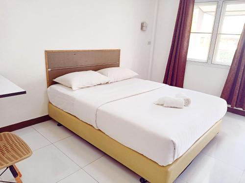 a bedroom with a large bed with white sheets at Goldenville in Ban Du