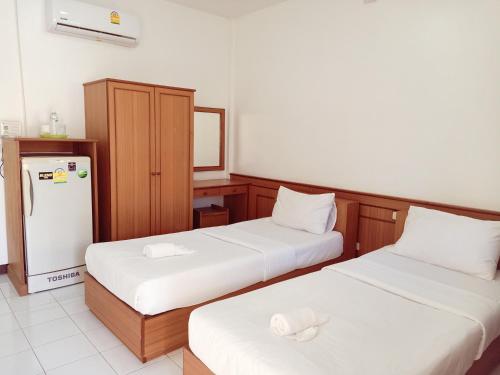 a room with two beds and a refrigerator at Goldenville in Ban Du