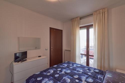 a bedroom with a bed and a television and a window at AM16 - Spazioso appartamento vicino stazione centrale in Perugia