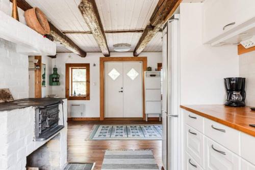 a kitchen with white cabinets and a white door at Hus Skärgården in Figeholm