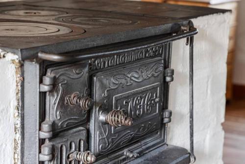 an old black stove with a wooden top at Hus Skärgården in Figeholm