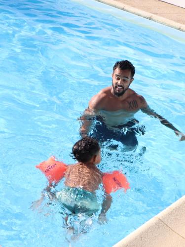 Ein Mann und ein Kind im Schwimmbad. in der Unterkunft La Caz en Sol Charentais - Le Fâ in Montpellier-de-Médillan