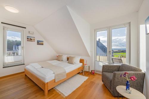 a bedroom with a bed and a couch and windows at Ferienhaus Adele in Ueckeritz