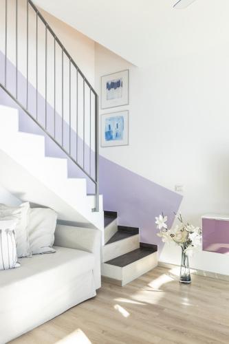 a white living room with stairs and a vase of flowers at Il Giardino Di Lory in Vercana