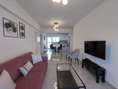 a living room with a couch and a flat screen tv at Hawaii Holiday Apartment 41 in Limassol