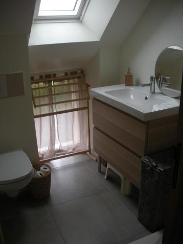 La salle de bains est pourvue d'un lavabo, de toilettes et d'une lucarne. dans l'établissement Maison de charme entre Golfe du Morbihan et Océan, à Sarzeau