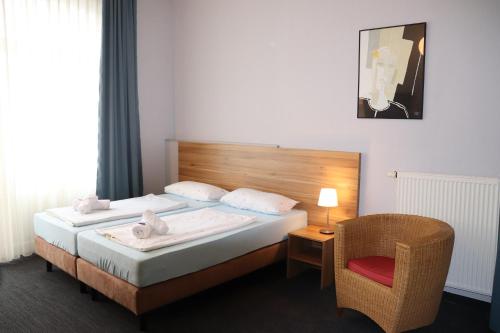 a hotel room with a bed and a chair at Hotel Garni Gästehaus der Kerckhoff-Klinik in Bad Nauheim