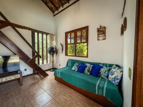 Una sala de estar con un sofá verde y una ventana. en Búzios Geribá 2 minutos a pé da praia, en Búzios