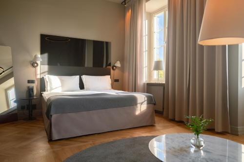 a hotel room with a bed and a table at Nobis Hotel Stockholm, a Member of Design Hotels in Stockholm