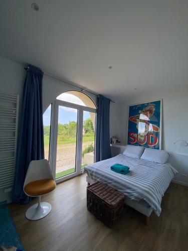 une chambre avec un lit et une grande fenêtre dans l'établissement Logement entier dans manoir à Trouville vue mer, à Trouville-sur-Mer