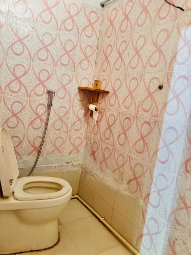 a bathroom with a toilet and a shower curtain at Hotel Himalayan View in Chakrāta