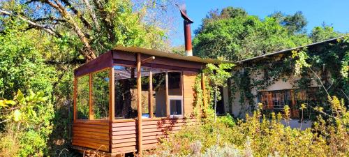 a small wooden house in the middle of a forest at Stanford Lake lodge in Haenertsburg