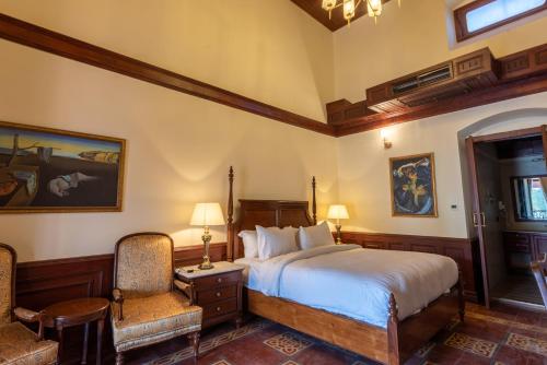 a bedroom with a bed and two chairs at Cecil by Pearl Continental in Murree