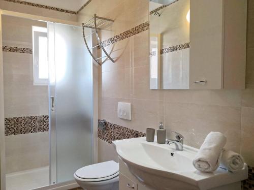 a bathroom with a toilet and a sink and a shower at Apartments Brnic in Baška
