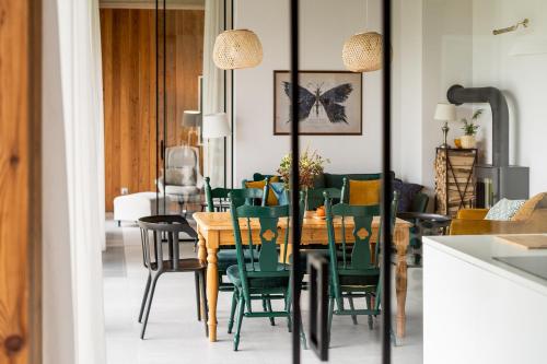 a dining room with a table and green chairs at Proste Chwile in Tylicz