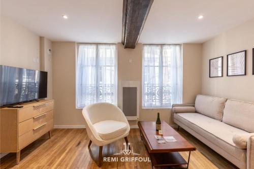 un salon avec un canapé et une télévision dans l'établissement Le Bois Bleu - 2nd Floor - City Center, à Honfleur