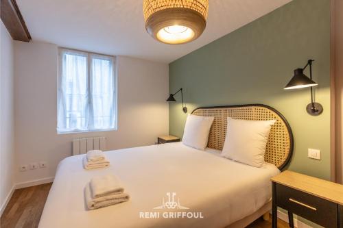 une chambre avec un lit avec des serviettes dessus dans l'établissement Le Bois Bleu - 2nd Floor - City Center, à Honfleur