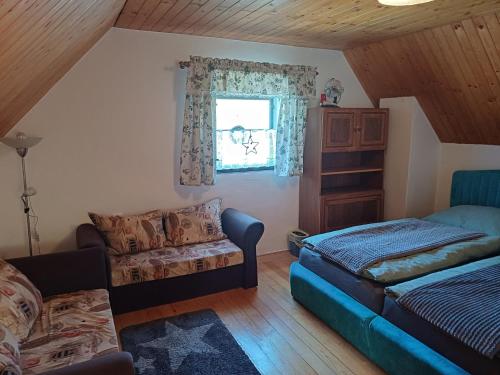 a living room with a bed and a couch at chaloupka Karolinka in Karolinka