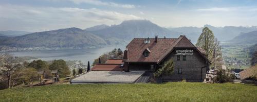 a house on a hill with a view of a lake at Gmundnerberghaus - ROOMS in Altmünster